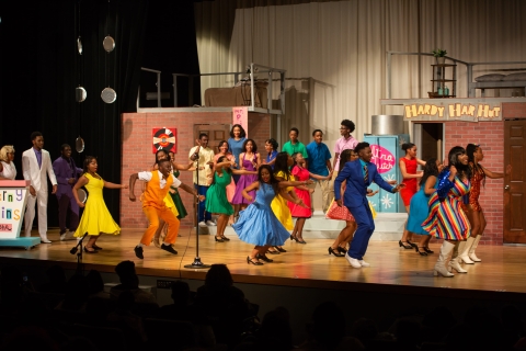 A group of students onstage dancing