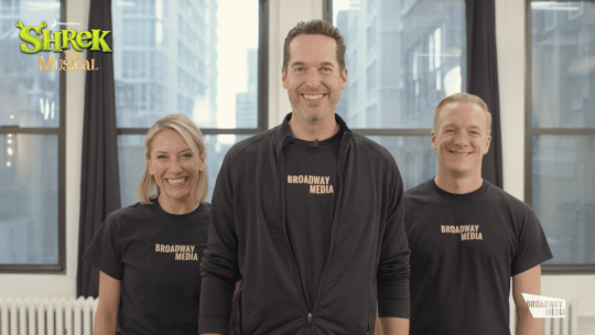 Three people in black shirts that say "Broadway Media" facing forward and smiling.