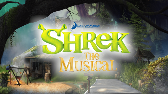 A curtain warmer of a forest with the Shrek the Musical logo