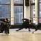 A group of dancers wearing black hats and black outfits performing a move.