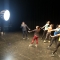 A choreographer demonstrating a move as four dancers behind perform the movement in front of bright lights.